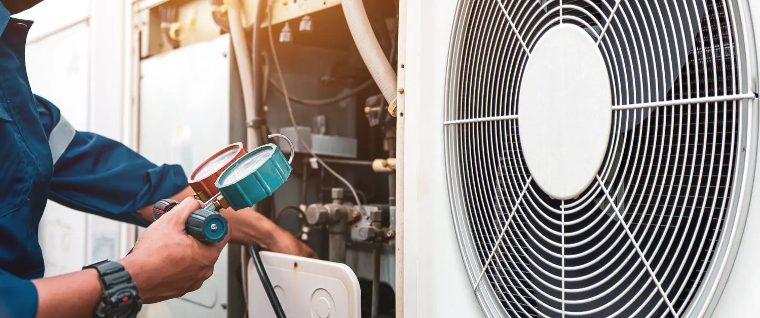 Outdoor AC condenser units beside a home in afternoon sun